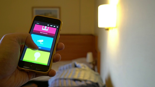 人们用智能手机来控制卧室的光线视频素材