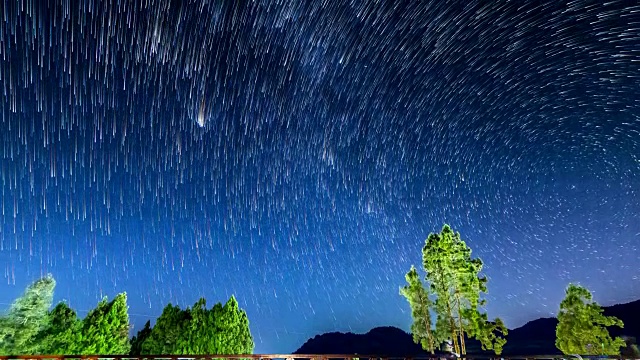 夜间星星在山上和树上的轨迹(倾斜拍摄)视频下载