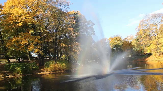 里加运河的喷泉和彩虹，流经堡垒公园的秋天背景与彩色的树叶视频素材