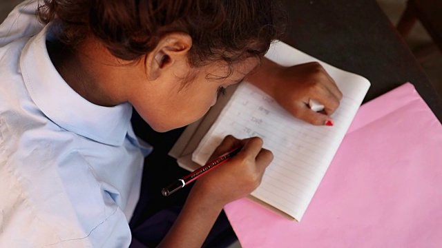 印度哈里亚纳邦一名女学生在笔记本上写字的特写视频素材