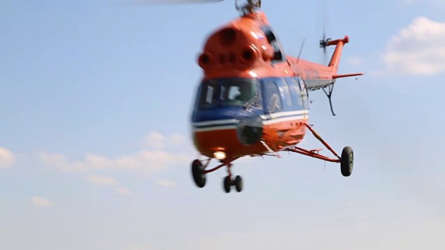 直升机低低地飞过田野。视频是从地面上拍下来的，直升机飞到摄像机前。视频下载