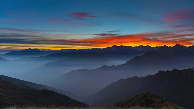 日落时阿尔卑斯山的全景，令人惊叹的彩色天空视频素材