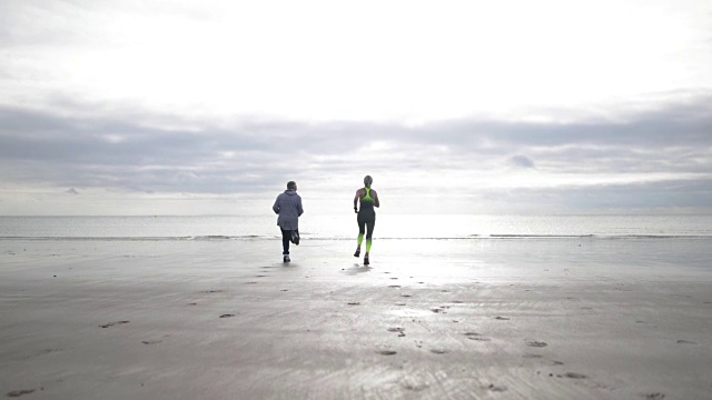 一对情侣在海滩上奔跑视频素材