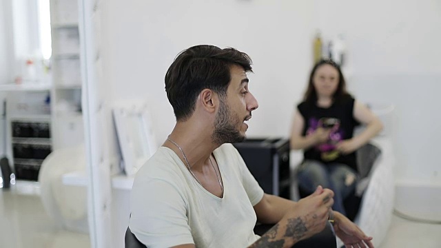 一名年轻的土耳其男子主持了一场大师班，谈论着染发的当前趋势。视频下载
