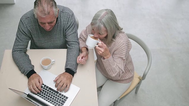 这是一对老年夫妇一起使用笔记本电脑的照片视频素材