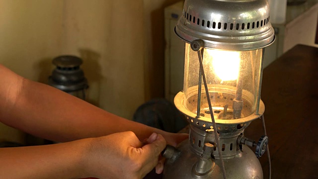 一名亚洲男子用泵柄点亮加压煤油灯。视频素材