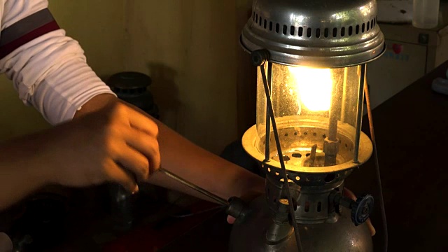 一名亚洲男子用泵柄点亮加压煤油灯。视频素材