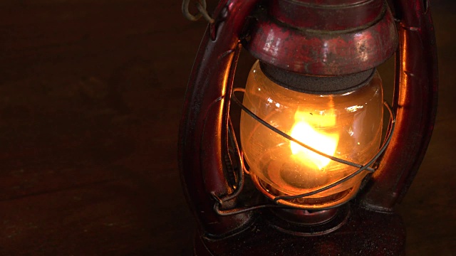 黑暗中的桌子上放着一盏古董油灯。视频素材