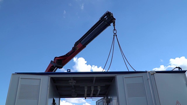 一个用链条吊着的建筑起重机顶着天空吊着货物视频下载