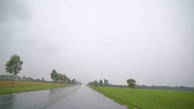 倾盆大雨下在城外的路上视频素材