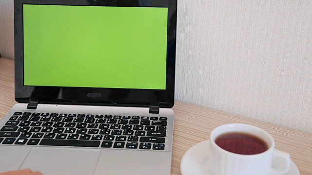 一个女人在用绿色屏幕的笔记本电脑。视频素材