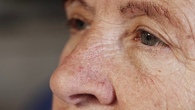 近距离肖像上的老女人的眼睛:肖像沉思的老年妇女视频素材