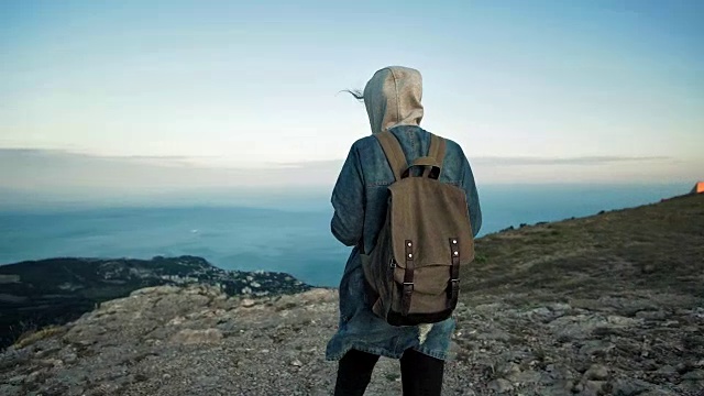 女旅行者背包行走和欣赏山的风景。视频下载