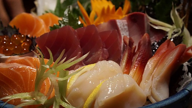 用筷子吃生的新鲜什锦生鱼片。日本料理和传统料理视频素材