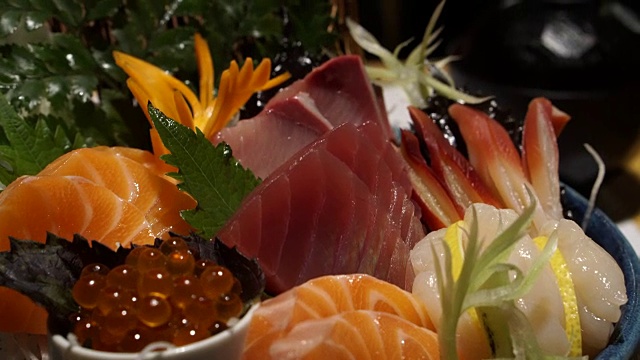 用筷子吃生的新鲜什锦生鱼片。日本料理和传统料理视频素材