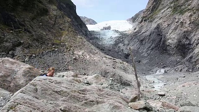 男性徒步旅行者走过冰川，向冰川望去视频素材