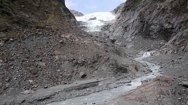 透过徒步者的脚可以看到冰川和远处的冰川视频素材