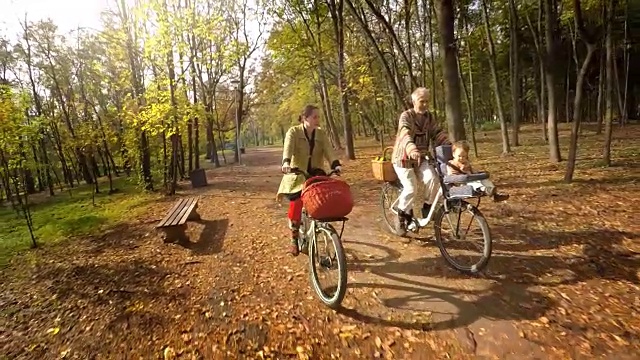 一家人和孩子在公园里骑车。放松的育儿视频素材