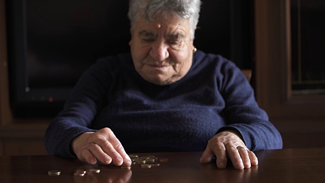 一位老妇人在桌上数硬币视频下载