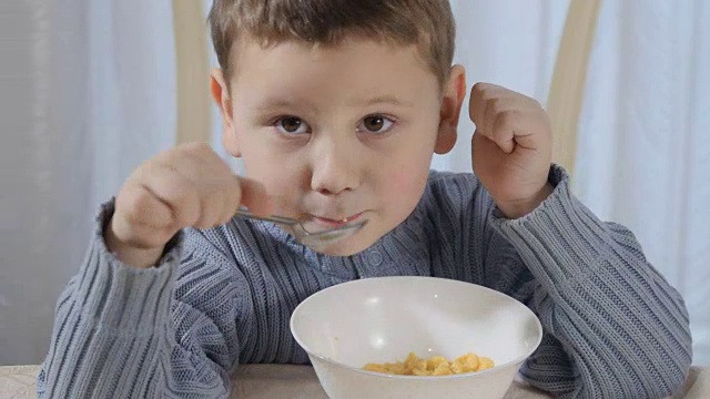 可爱的小男孩吃玉米片竖起大拇指视频下载