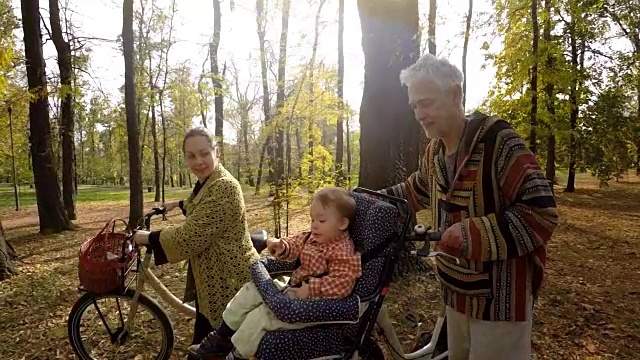 一家人和孩子在公园里骑车。放松的育儿视频素材