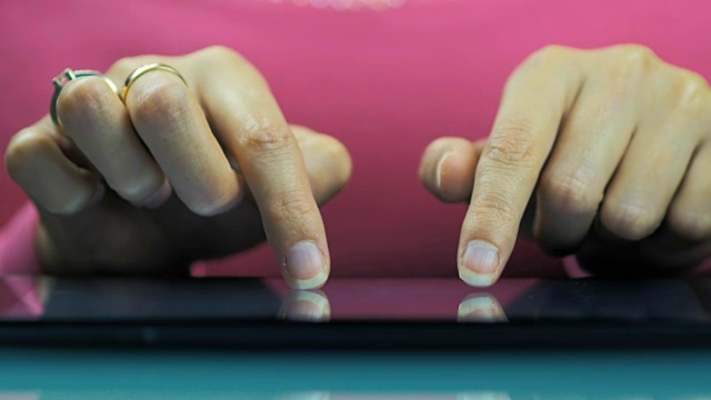 一个年轻女孩在平板电脑上写电子邮件的女性手的特写。视频素材