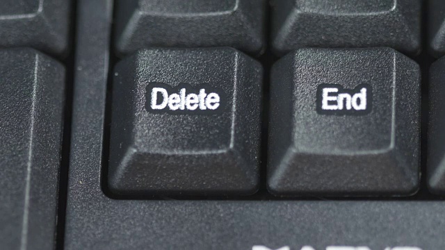 人的手指在电脑键盘上按下删除键的特写视频下载