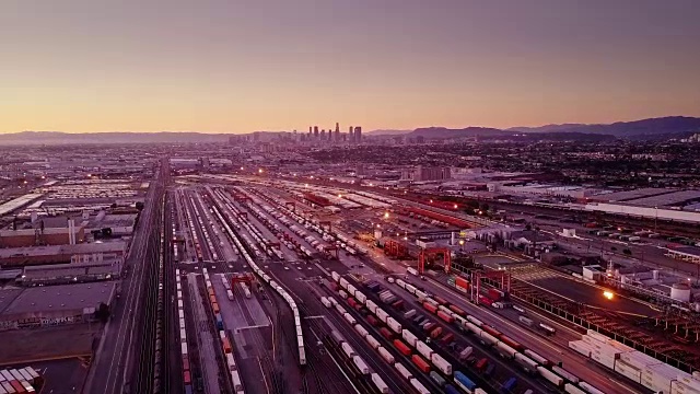 航空拍摄的多式铁路院子与市中心洛杉矶天际线视频素材