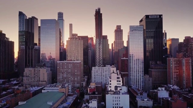从空中俯瞰曼哈顿，摩天大楼之间升起了太阳视频下载