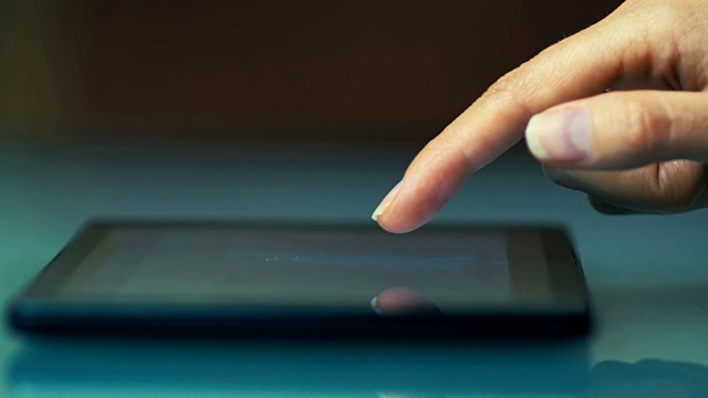 一个年轻女孩用一只手在平板电脑上写电子邮件的特写。视频素材