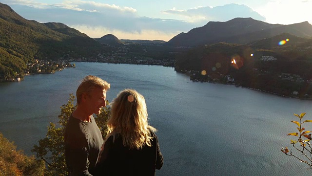 一对成熟的夫妇徒步到山上的湖上去欣赏风景视频素材