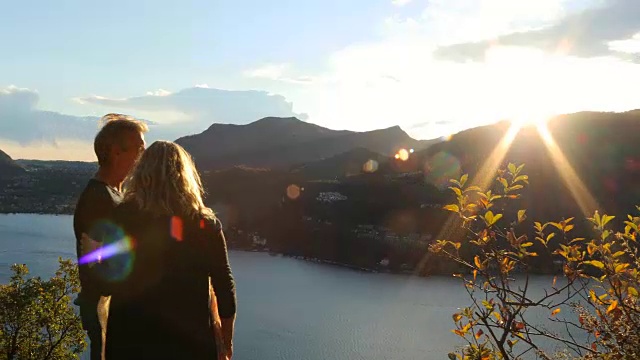 一对成熟的夫妇徒步到山上的湖上去欣赏风景视频素材
