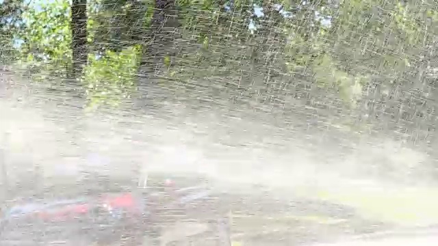 夏天的下午，青少年朋友们在消防栓喷出的水雾中奔跑视频素材