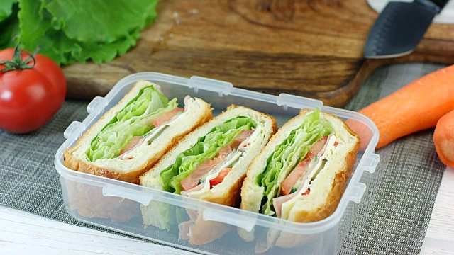 女人把做好的三明治放进午餐盒里视频素材