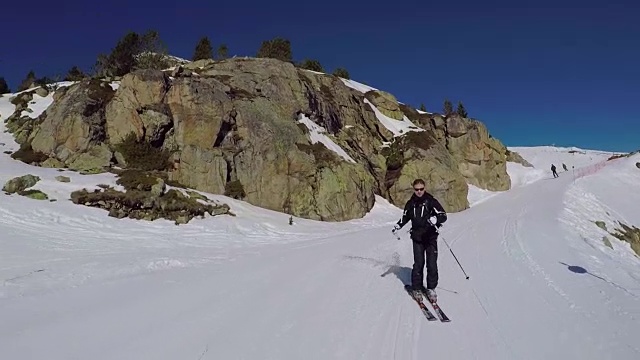 滑雪者从山上雕刻的冬季滑雪坡道上滚下来。视频素材