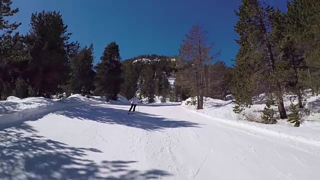 在阳光下，滑雪者在雪道上翻滚。视频素材