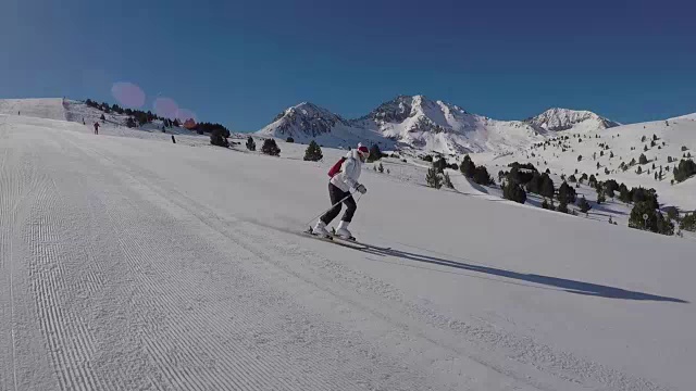 女人们在雪坡上滑雪，阳光照耀着雪山。视频素材