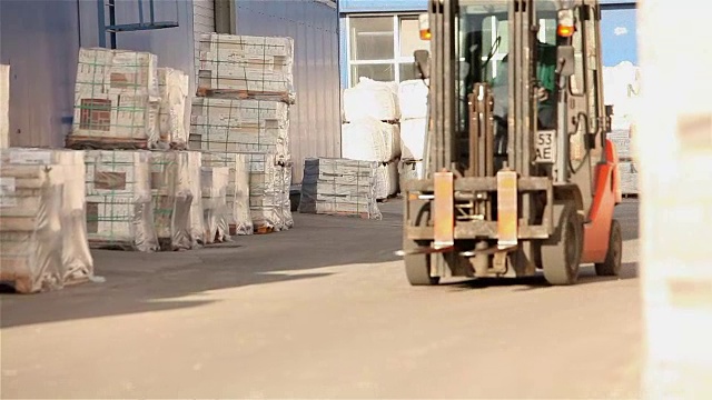 装载机在仓库中运输货物，在仓库中装载机，大型企业仓库，工业内部视频素材