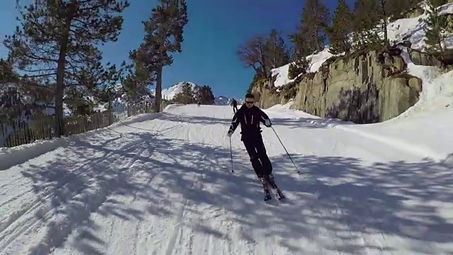 滑雪者从山上雕刻的冬季滑雪坡道上滚下来。视频购买