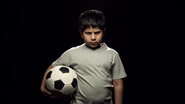 一个男孩拿着足球的肖像视频素材