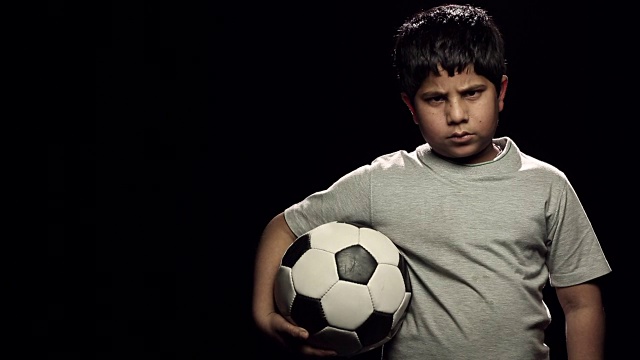 一个男孩拿着足球的肖像视频素材