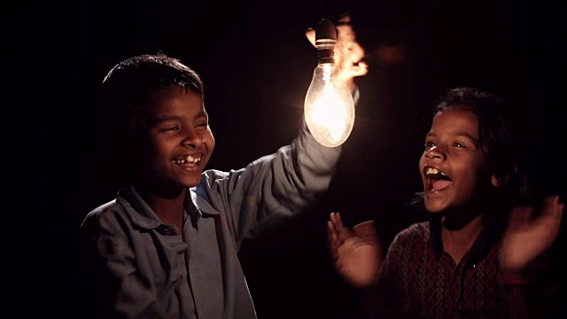 男孩和女孩点亮了一个电灯泡视频下载