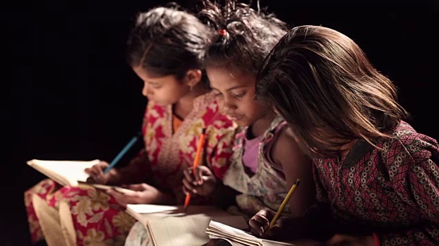 三个女孩在一本书上写字视频素材