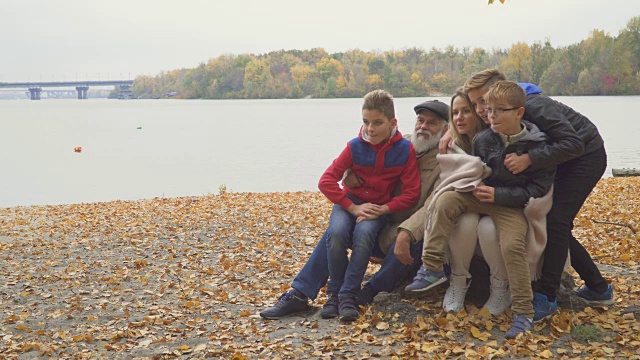 快乐的爷爷和成年的女儿和孙子在秋天公园视频下载