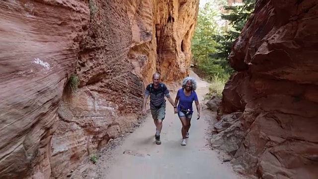 4K超高清:老年夫妇徒步穿越峡谷视频素材
