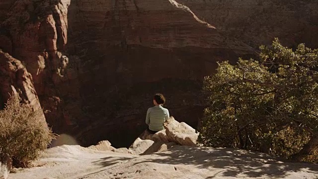 4K超高清:年轻女子坐在悬崖上视频素材