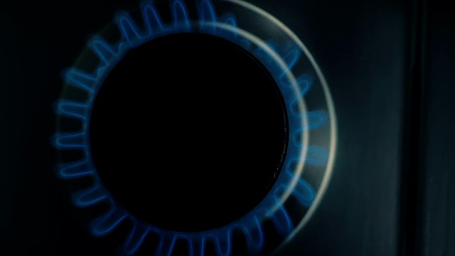 慢镜头:在黑暗中，家里炉子上的煤气炉慢慢地随着煤气发光。前视图。视频下载