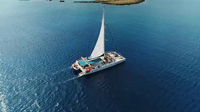 在塞浦路斯阿伊纳帕的地中海上驾驶双体船。空中无人机拍摄。视频下载