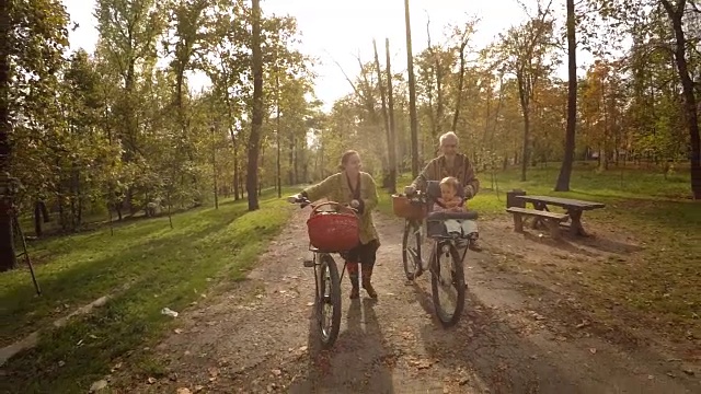 摩登家庭和在公园里骑车的孩子。放松的育儿视频素材