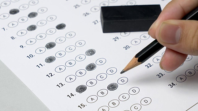学生在做考试测试时，通过填写冒泡的答案和擦去铅笔标记来更改答案。视频素材